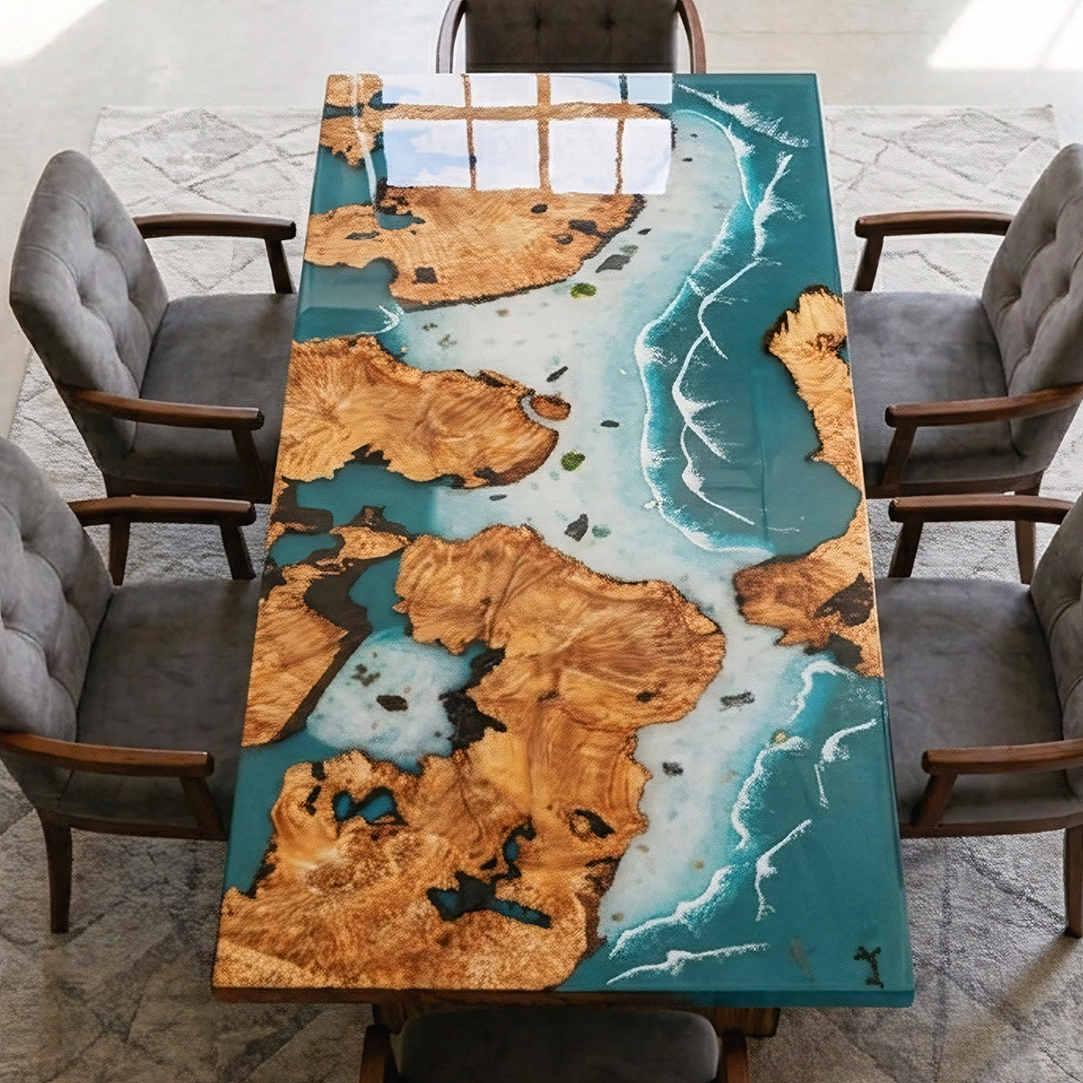 Elevated view of a poplar burl dining table with turquoise resin, pale blue coastal details and gray upholstered chairs.